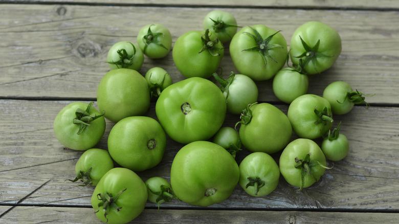 Green tomatoes on wooden table