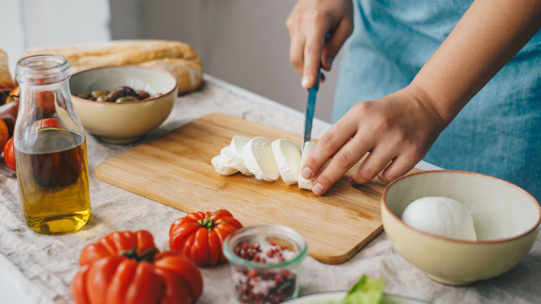 Woman cutting buffalo mozzarella 