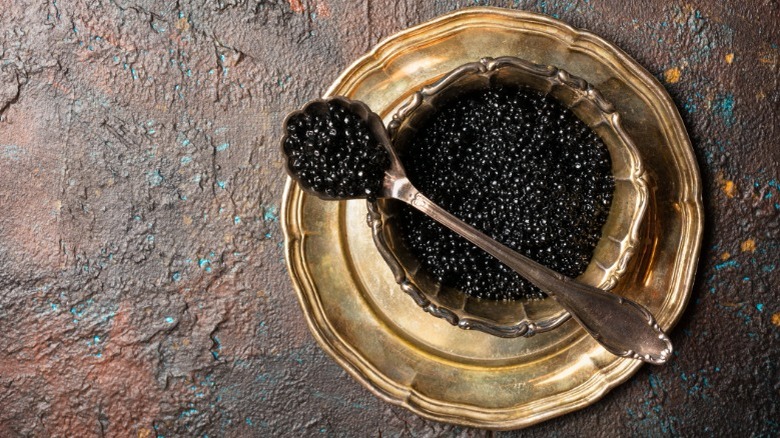 Gold dish of black caviar