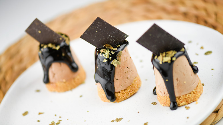 Mousses covered with chocolate and gold leaf