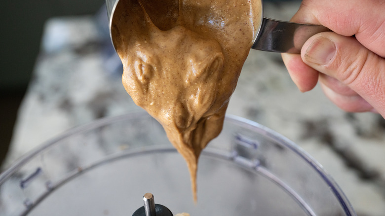 Dumping peanut butter into blender