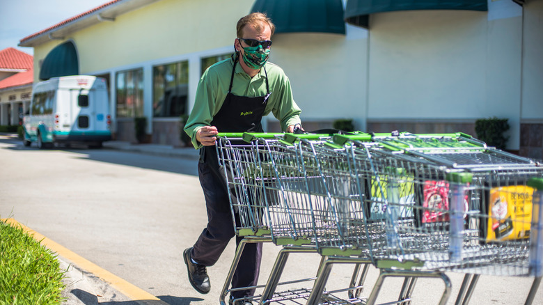 Publix employee pushing carts in parking lot