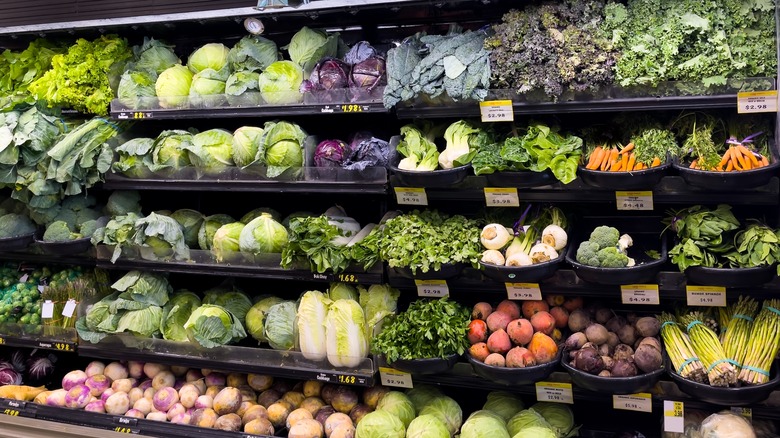 rows of fresh vegetables in the produce aisle at the grocery store