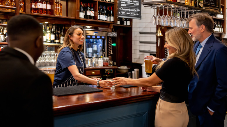 Customer taking a drink from a bartender