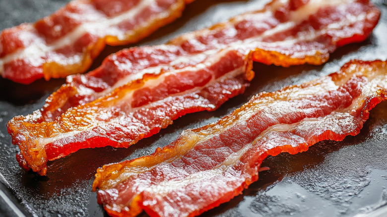 A closeup of strips of cooked crispy bacon on a grill plate