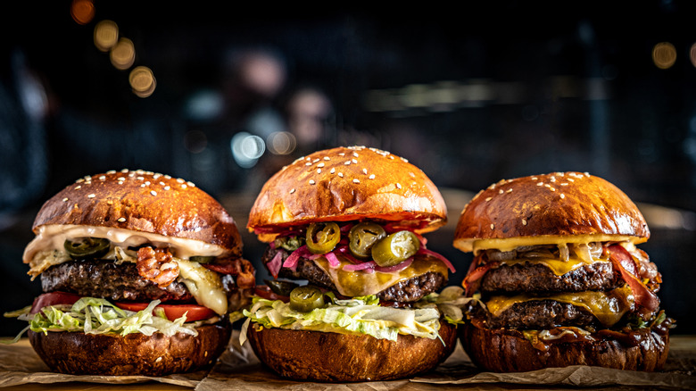 a line of three different gourmet burgers