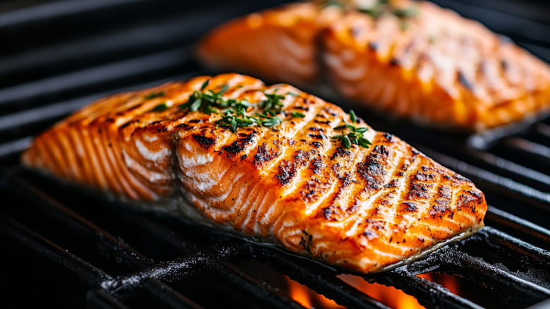 two pieces of hot grilled salmon on a coal grill