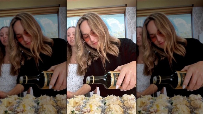 Giada De Laurentiis pouring olive oil on pasta in a cupcake tin