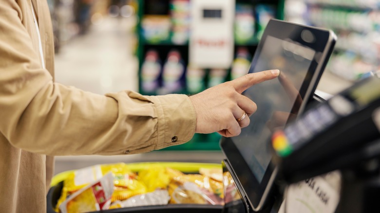 Man using self checkout kiosk