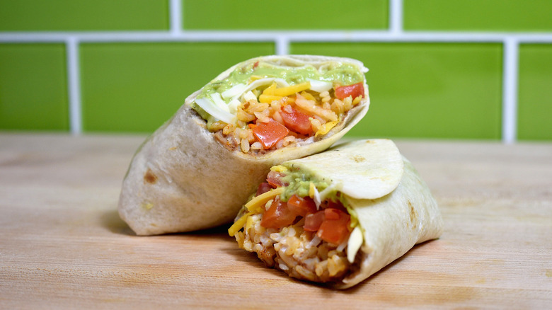Taco Bell 7-Layer Burrito cut in half and stacked on wood