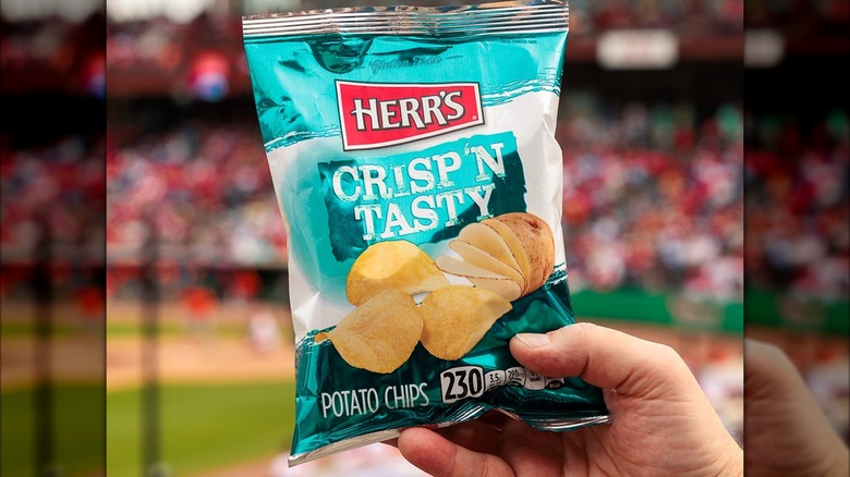 Hand holding a bag of Herr's chips