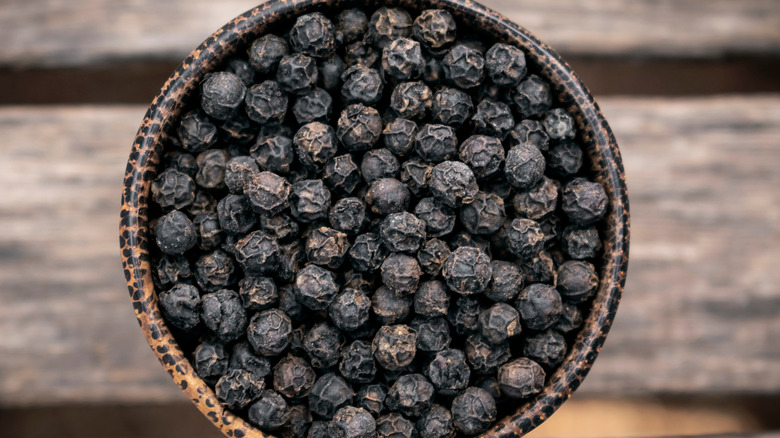 Black peppercorns in bowl