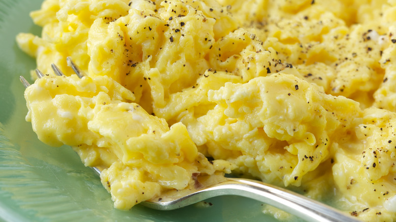 Fork scooping peppery scrambled eggs