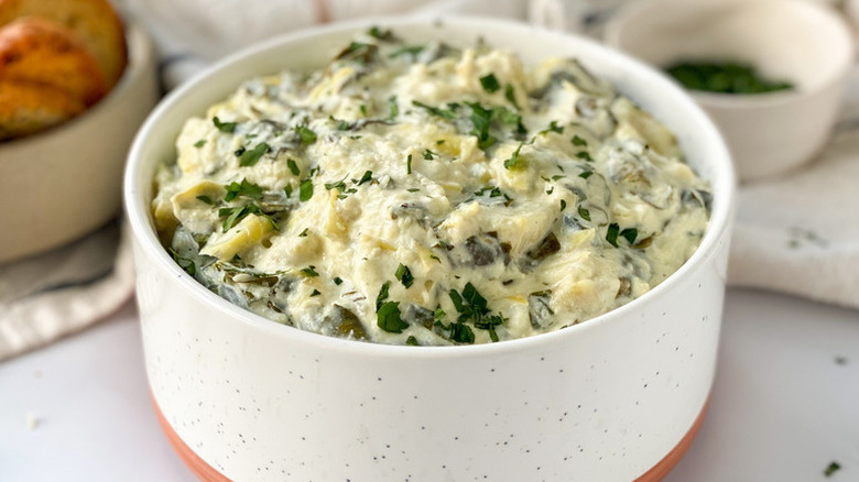 Spinach artichoke dip in white bowl