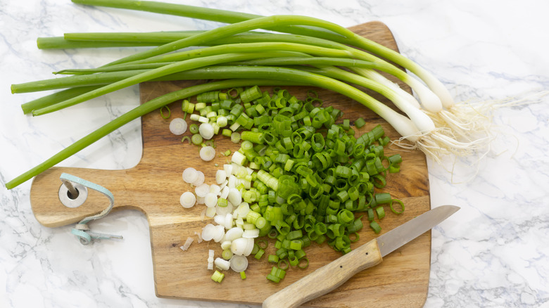 chopped scallions on board