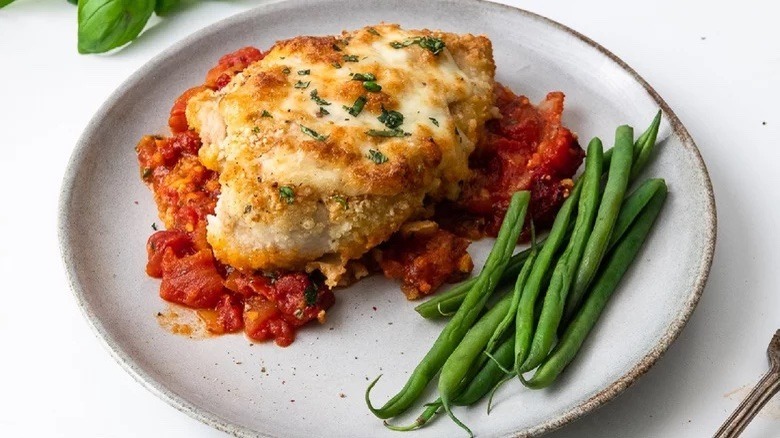 Crispy chicken Parmesan and green beans on a plate 