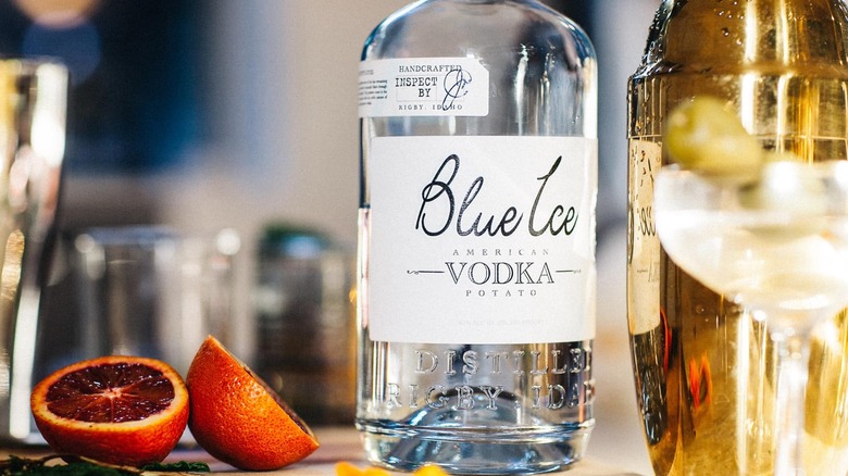 Blue Ice vodka bottle with cocktail shaker and blood oranges