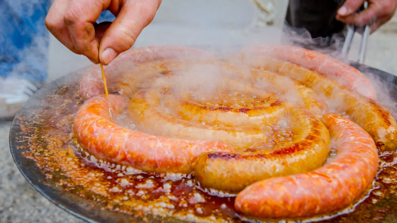 hand pricking sausage with toothpick