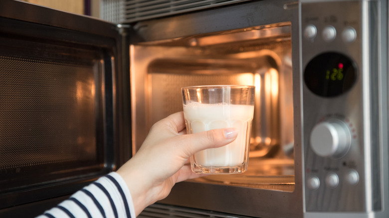 Arm grabbing milk from microwave