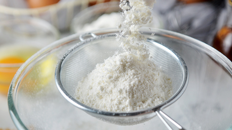 Sifting flour into a bowl