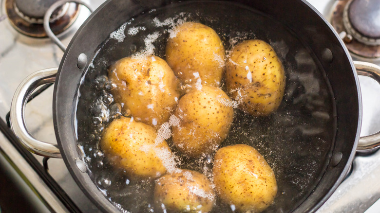 Potatoes boiling in dark pot