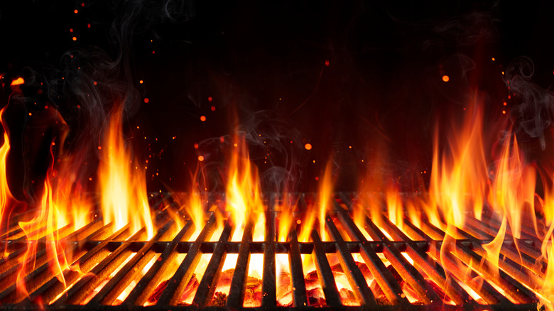 Flames rising above grill grate