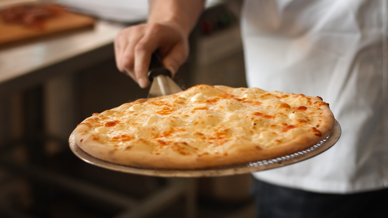 Cooked pizza on pizza peel