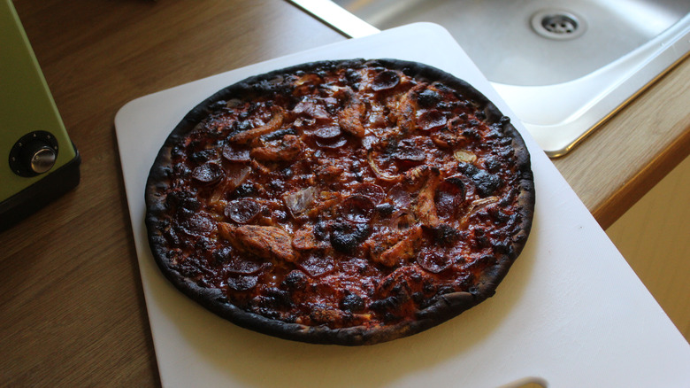 Burnt pizza on cutting board