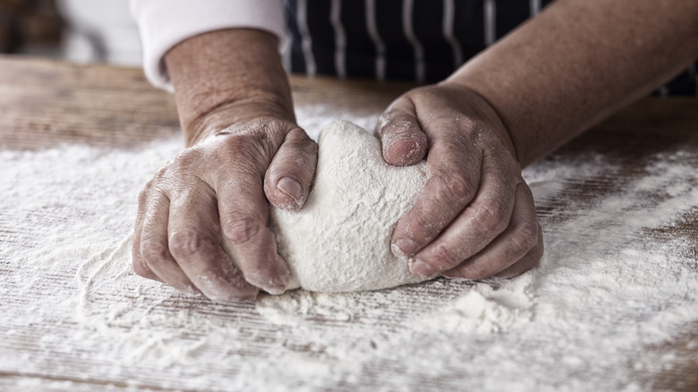 Two hands kneading dough