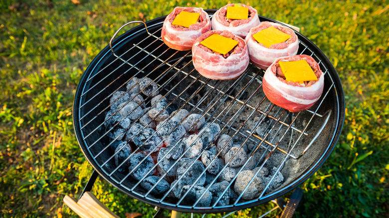 Bacon-wrapped burgers on grill