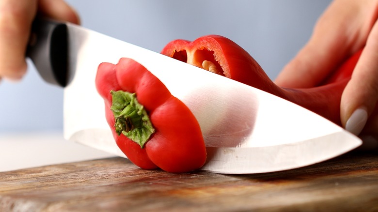 Knife cutting red pepper top