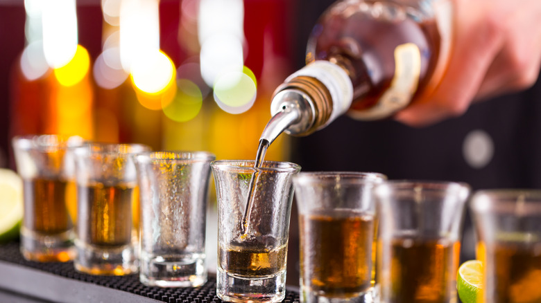 Person pouring shots in glasses