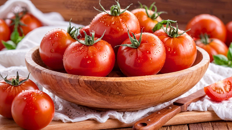 Bowl of large tomatoes with drops of water on them