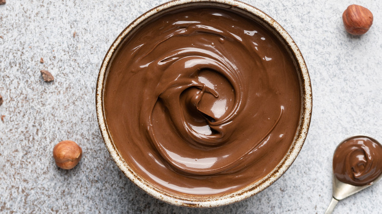 Hazelnut paste in bowl with nuts