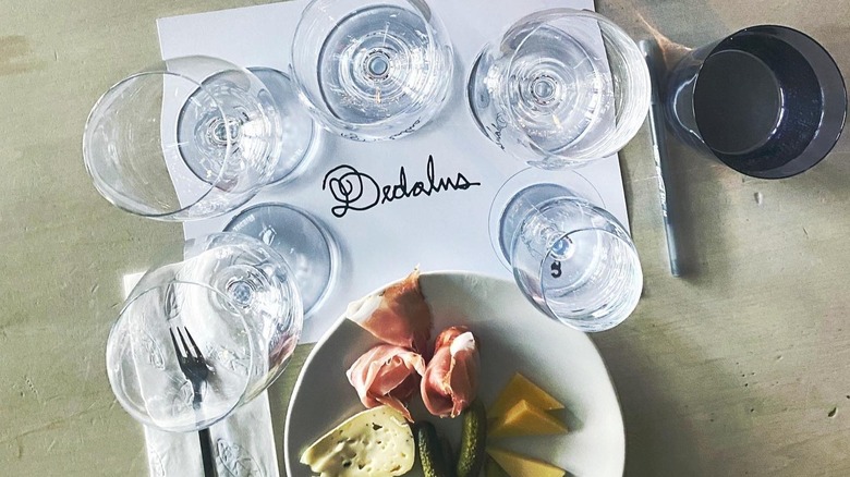 Dedalus placemat with wine glasses and charcuterie