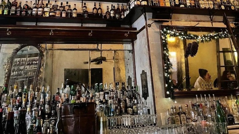back of bar lined with bottles and mirrors
