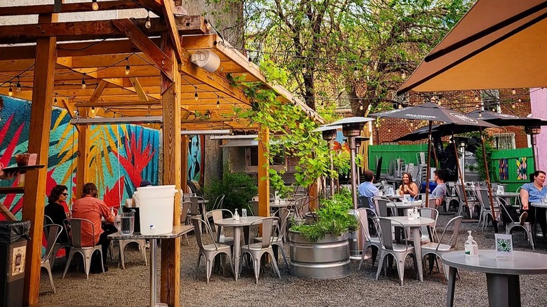 wooden trellis with lights and tables underneath