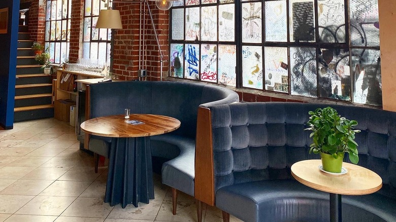 curved velvet banquettes with graffiti windows