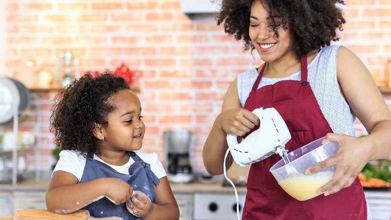 Woman beating eggs with electric mixer