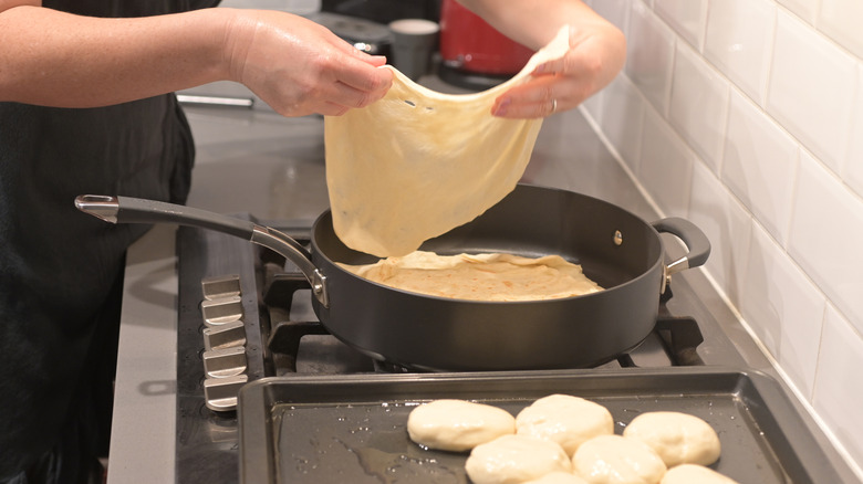 woman making muflitas pan stove