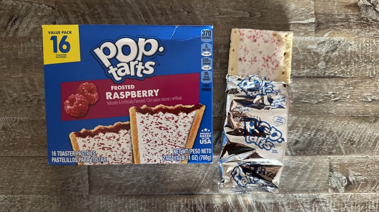 Frosted raspberry Pop-Tart box next to unwrapped pop-tart