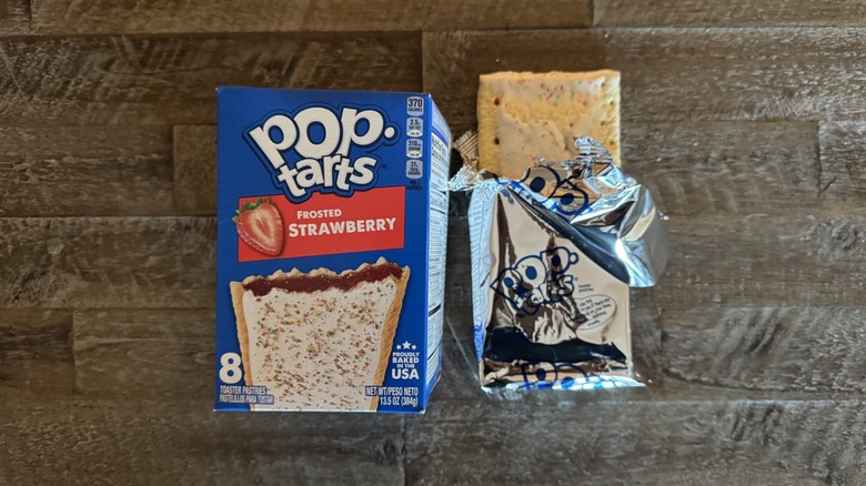 Frosted strawberry Pop-Tart box next to unwrapped pop-tart