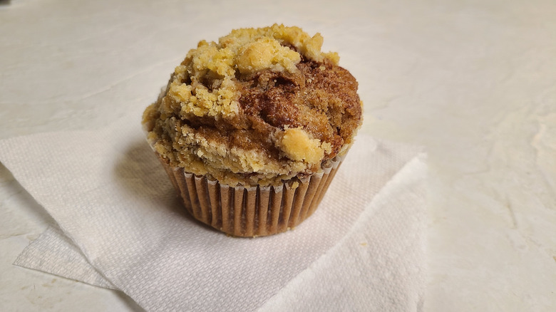 Cinnamon chip muffin on a paper towel on a white table