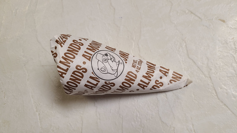 Buc-ee's paper cone filled with almonds on a white table