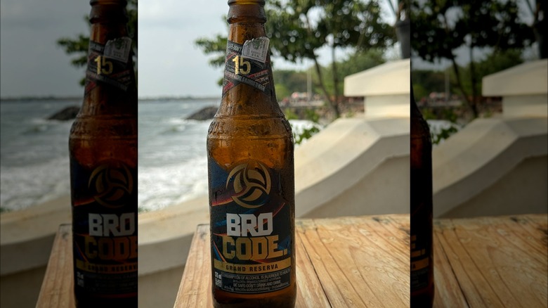 A bottle of Bro Code resting on a table by the ocean