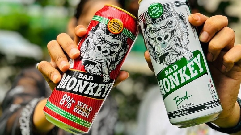 Two types of Bad Monkey beer cans being held up to the camera