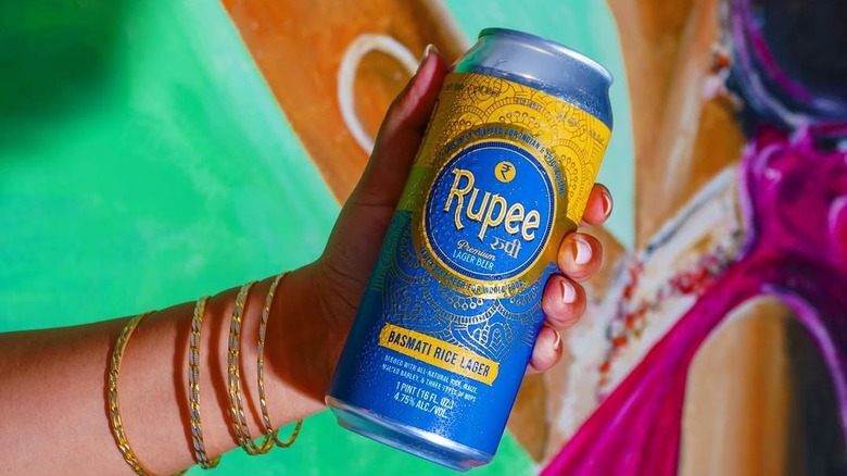 A can of Rupee Basmati Rice Lager being held in a hand