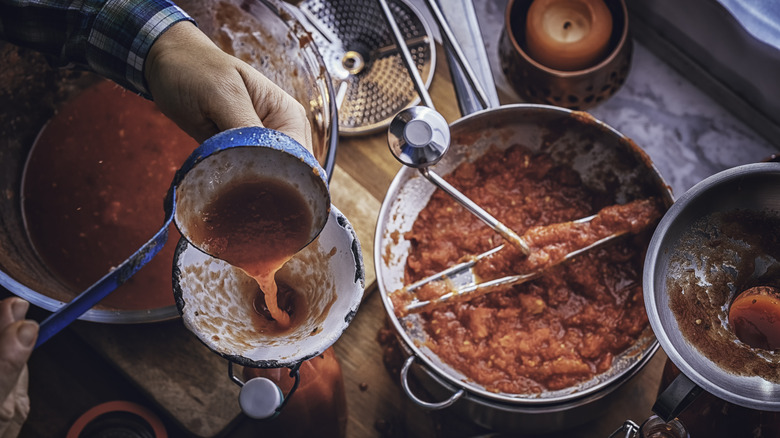 putting tomato sauce in containers