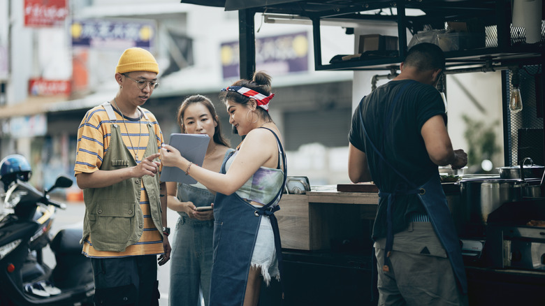 Woman showing tablet to people