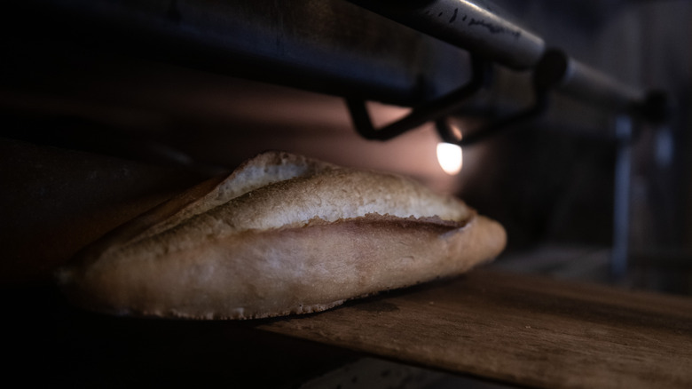 Bread baking on wooden peel
